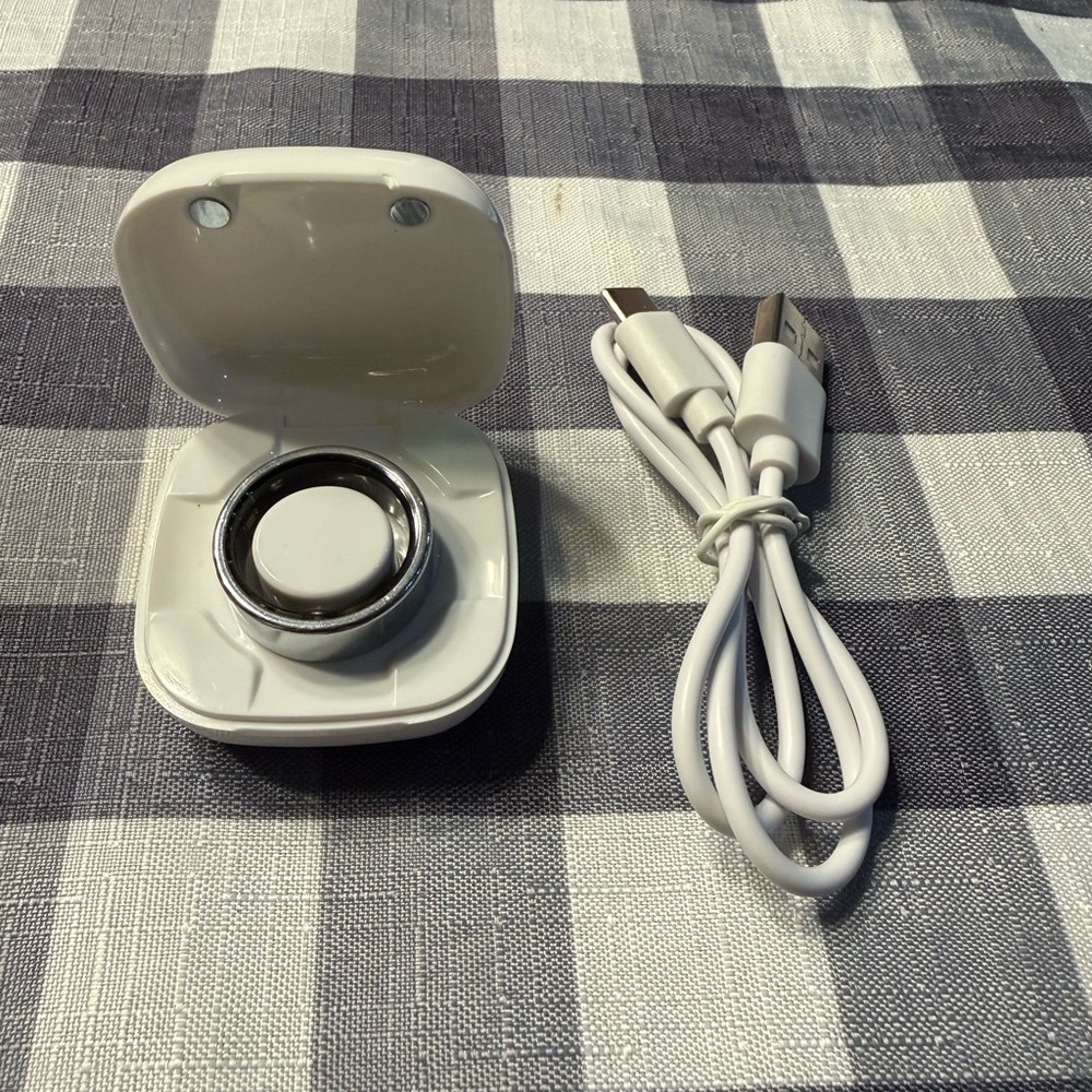 Smart Ring with charging case and cord.